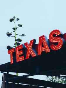 Christina Is heading to Texas, image shows a Texas sign.